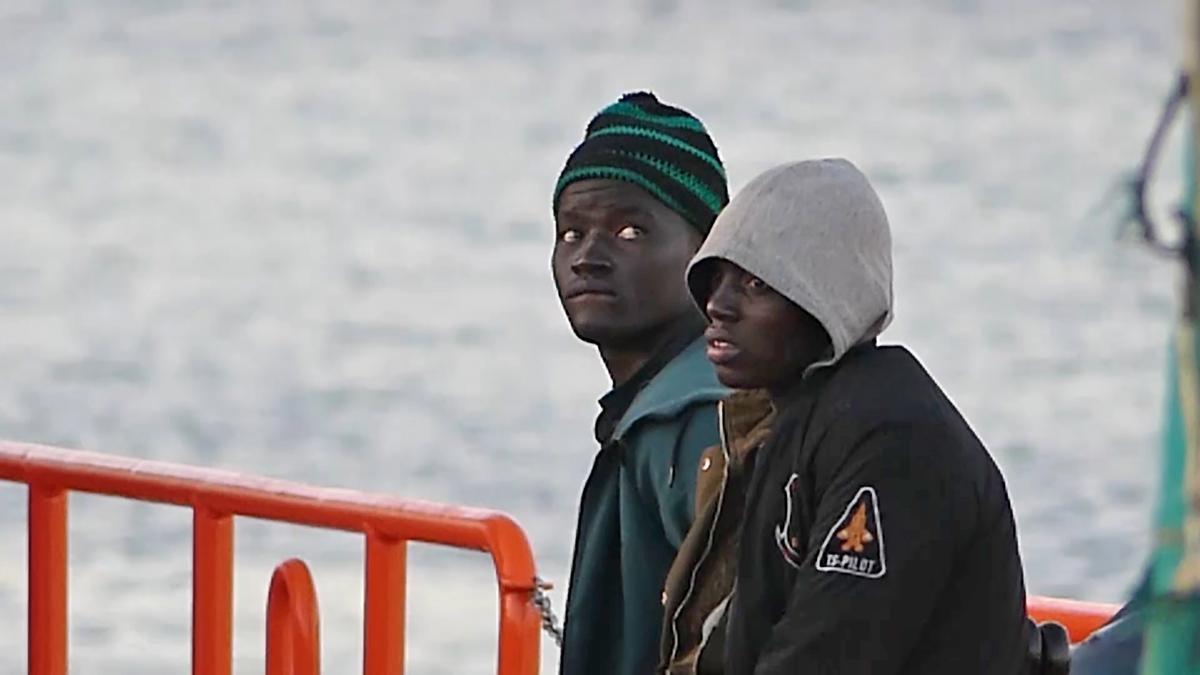 Dos jóvenes migrantes bajan de un barco de la Cruz Roja en el puerto de Arguineguín (Gran Canaria, España)