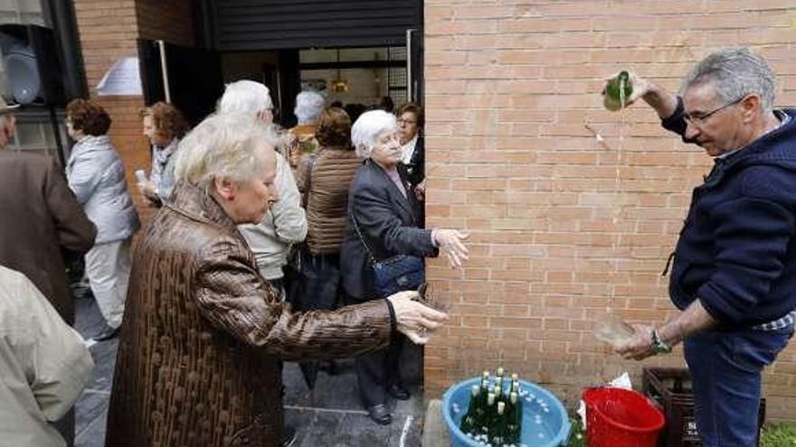 Jesús Paniagua escancia sidra a las puertas del templo.