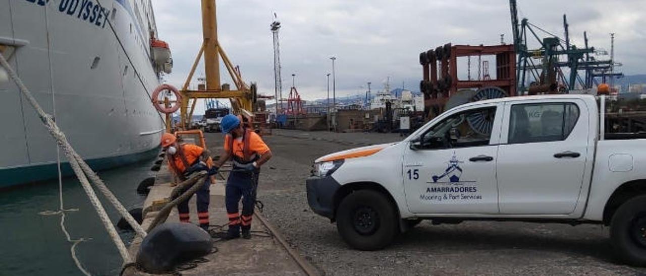 Dos amarradores, con equipos protectores a pie de muelle en el Puerto de La Luz durante una operativa reciente.