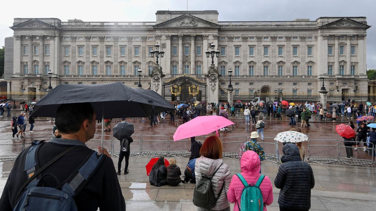 People shelter under their umbrellas as they gather outside Buckingham Palace, following a statement from the Palace over concerns for Britain's Queen Elizabeth's health, in London, Britain September 8, 2022. REUTERS/Toby Melville