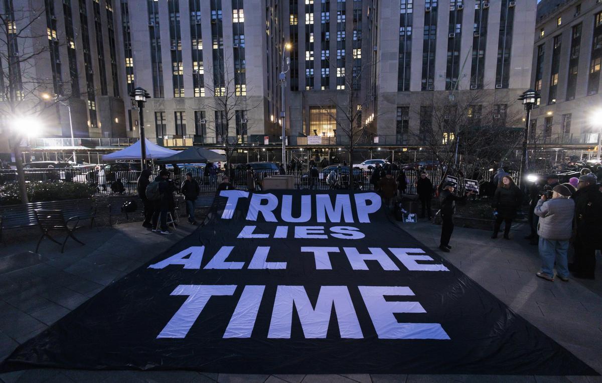  La gente despliega un cartel en el que se lee en inglés Trump miente todo el tiempo al otro lado de la calle del edificio de la Corte Penal de Nueva York, poco después de la acusación del ex presidente Donald J. Tump, hoy, en Nueva York .