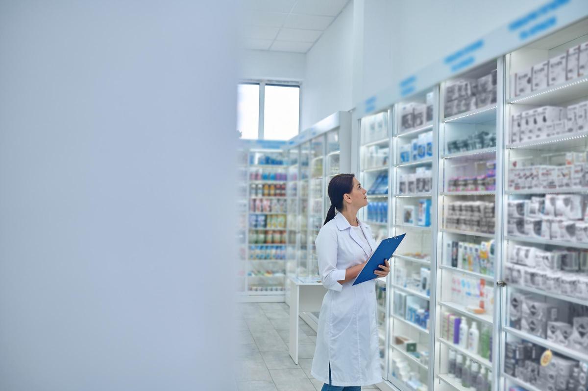 Your medication. Successful female pharmacist passing medication and man holding girl
