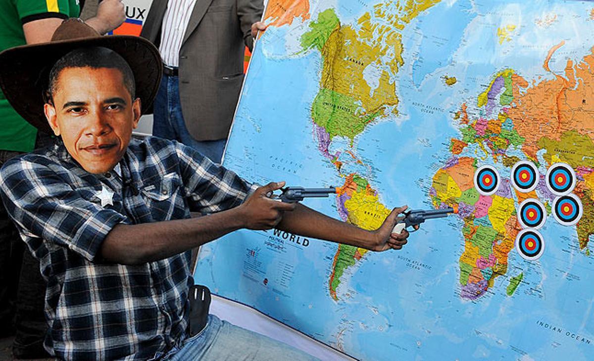 Un pacifista disfressat amb un vestit de ’cowboy’ i una careta d’Obama apunta a un mapa on estan assenyalats els punts del planeta on tropes nord-americanes participen en conflictes armats. Aquest dimecres, davant el londinenc palau de Buckingham durant una protesta contra la visita del president nord-americà.
