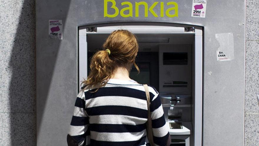 Una cliente saca dinero de un cajero de Bankia en una imagen de archivo.