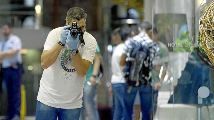Un agent de la policia forense examina l&#039;escenari del tiroteig al carrer Pintor Fortuny de Barcelona