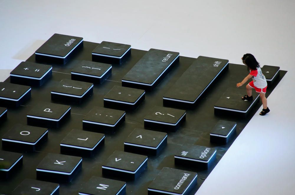 Una niña se sube a la maqueta gigante de un teclado en un centro comercial de Pekín.