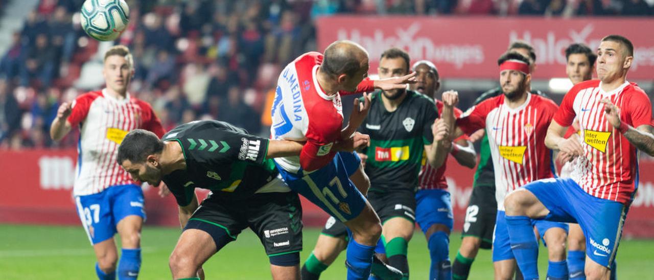 Yacine Qasmi intenta rematar el balón ante Unai Medina en una jugada de estrategia del Elche.