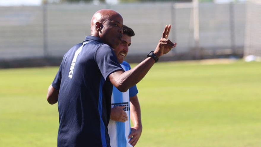 Dely Valdés, junto con un jugador malaguista.