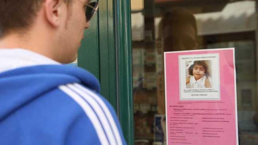 Un hombre mira en un comercio zamorano el cartel de apoyo a la niña Daniela.