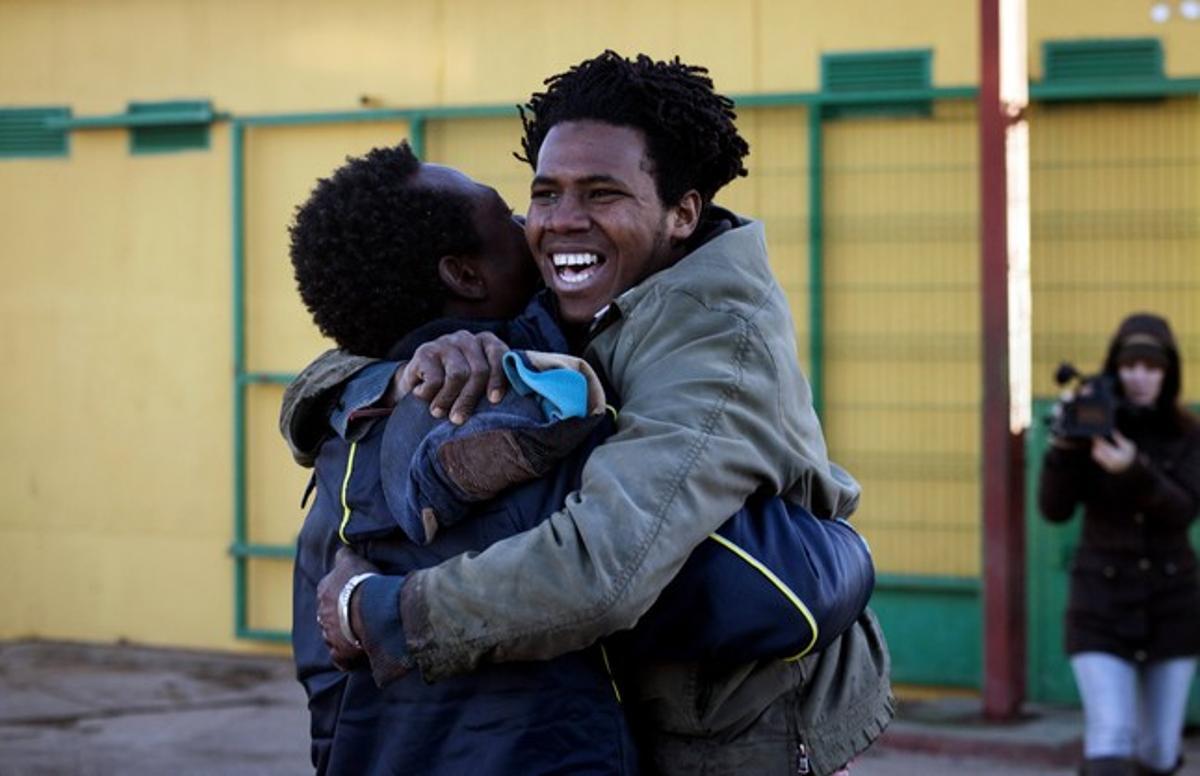 Dos immigrants s’abracen a l’arribar al CETI de Melilla, aquest dimecres, després de saltar la tanca.