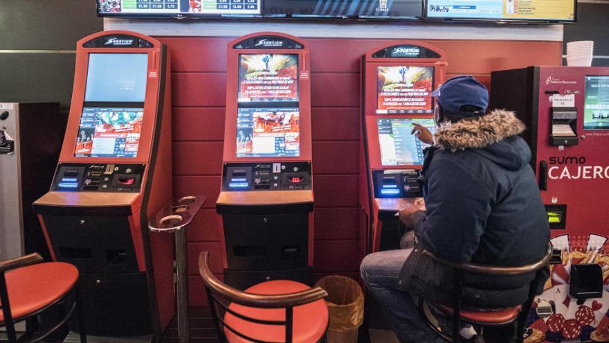 Un usuari posa diners en una màquina del Bingo la Cerveseria.