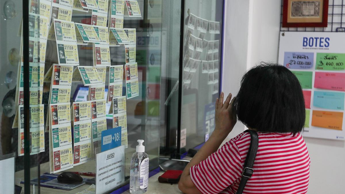 Una mujer comprando Lotería de Navidad en una administración