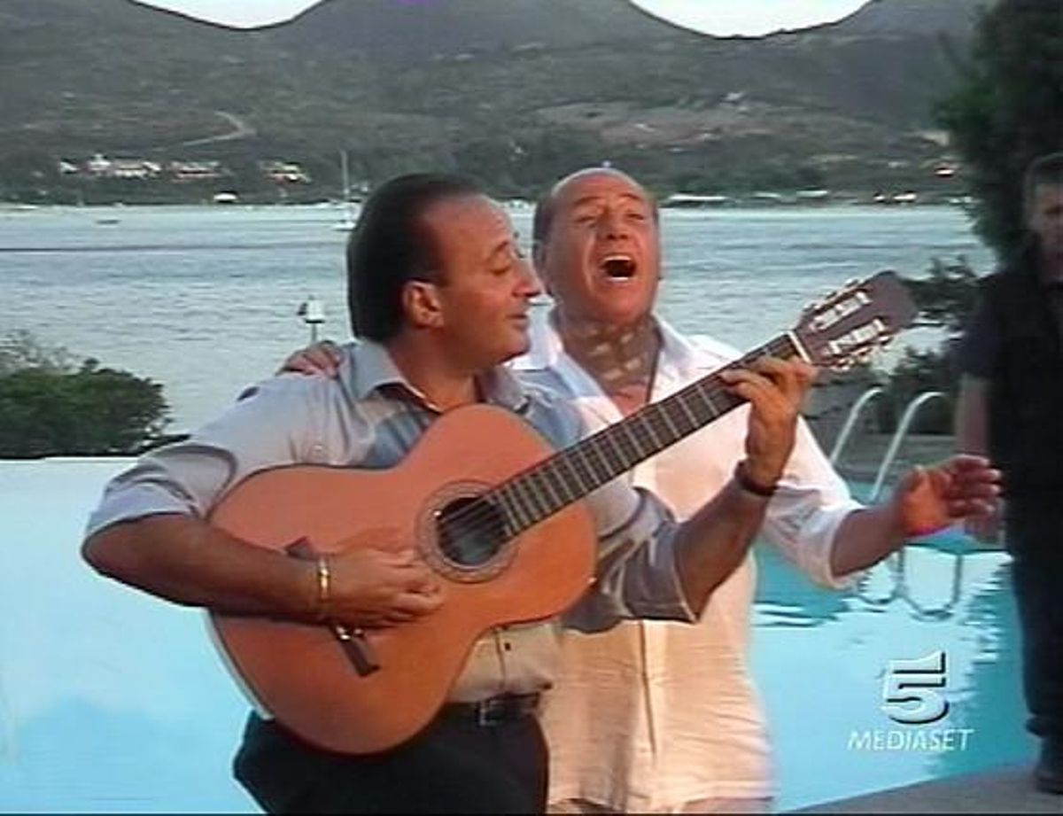 Imatge de televisió en què es veu Berlusconi (dreta) cantant amb el ’showman’ italià Mariano Apicella, durant una festa a l’illa de Sardenya, el setembre del 2003.