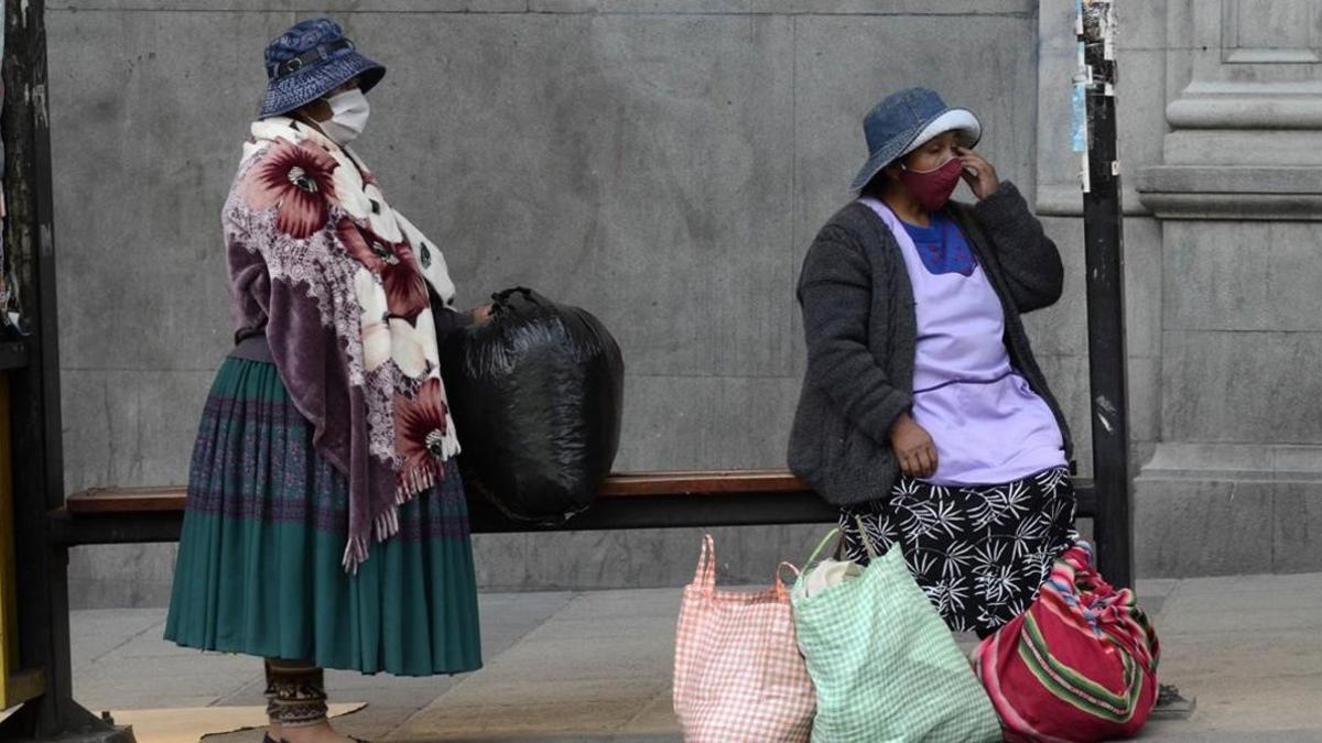 Mujeres esperan el autobús en una calle de La Paz, la capital de Bolivia.