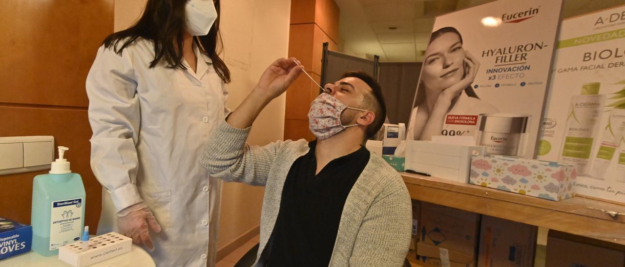 Un usuario se hace el test de antígenos en presencia de una sanitaria en una farmacia de Castelló.