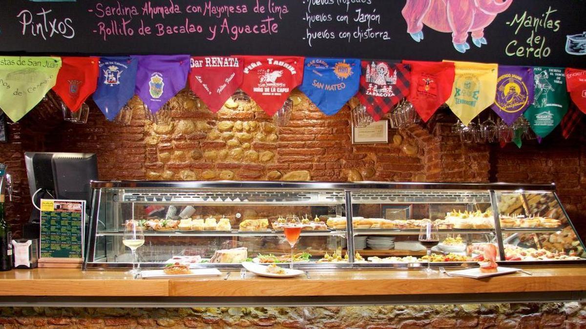 La barra de La Cava Aragonesa ofrece una amplia variedad de cazuelas, mariscos, carnes, embutidos, quesos, pinchos y tapas, junto con una cuidada selección de productos ibéricos.
