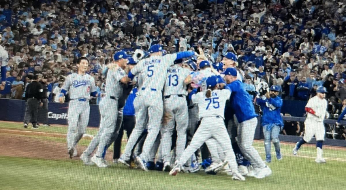 Los Ángeles Dodger celebran, sobre el 'diamante' de los Toronto Bluw Jays, su nuevo título mundial de béisbol.gers