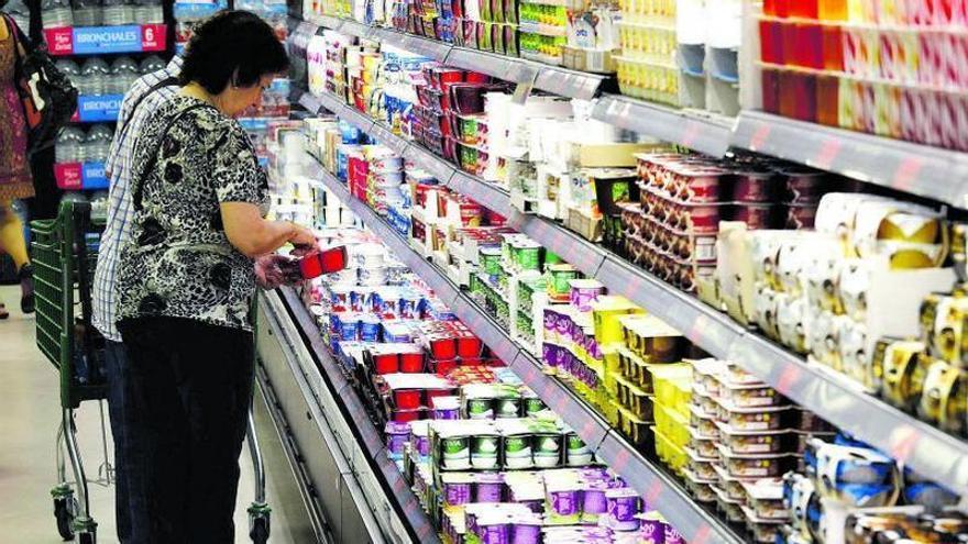 Una clienta de un supermercado mira los precios antes de escoger un pack de yogures, esta semana en Zaragoza. | JAIME GALINDO
