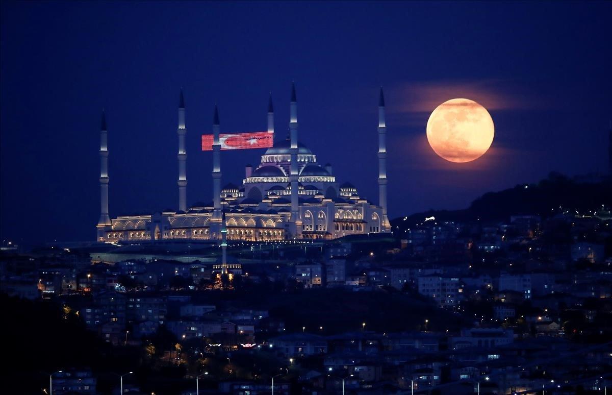 La luna llena se eleva sobre la Mezquita Camlica.