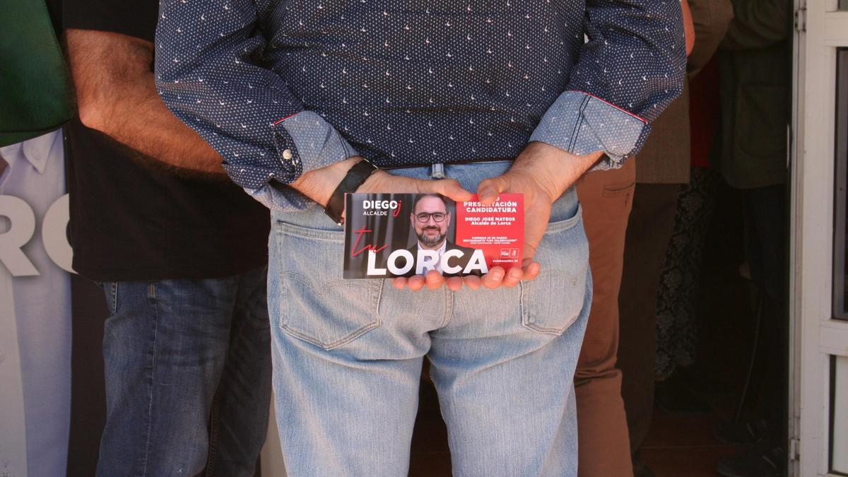 Un comensal aguarda para entrar al acto con su entrada en la mano.