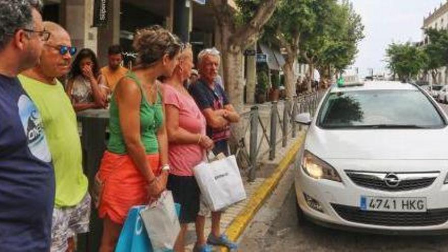 Un grupo de personas espera un taxi en la parada de la avenida de Bartomeu Rosselló.