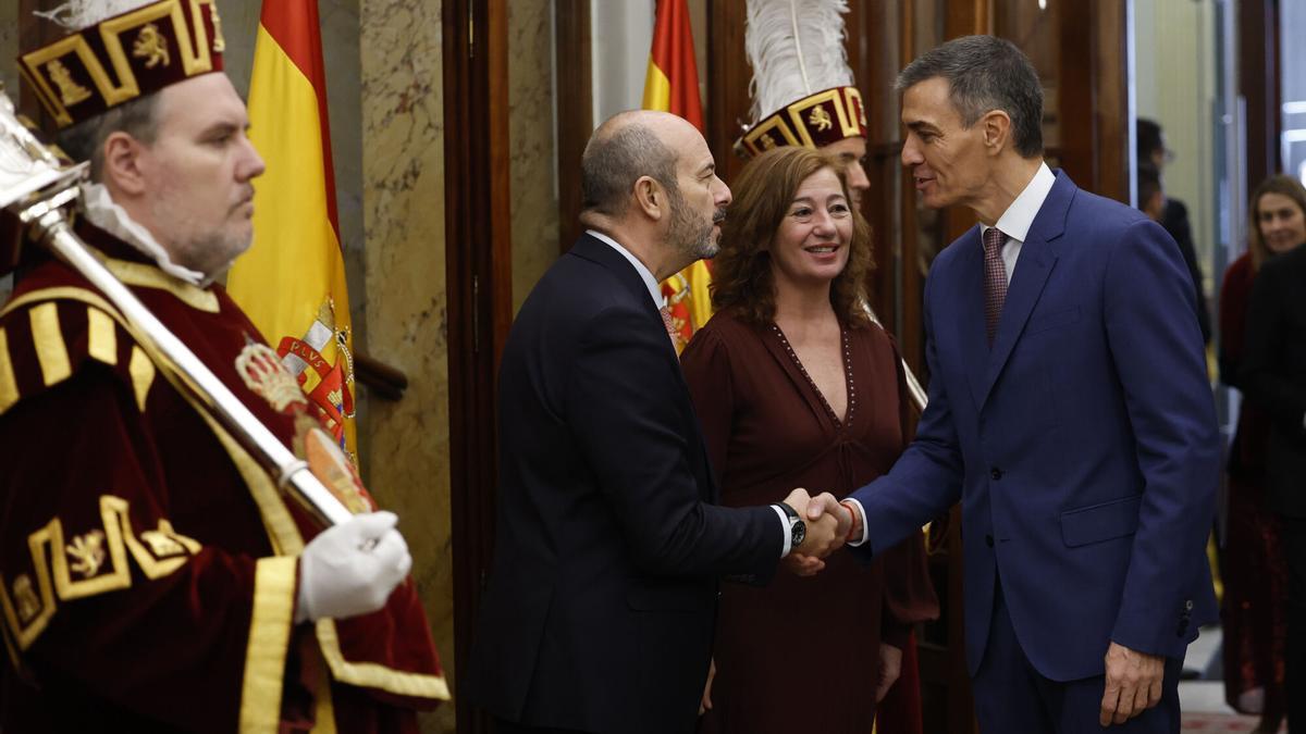 El presidente del Senado, Pedro Rollán (i), saluda al presidente del Gobierno, Pedro Sánchez, a su llegada al acto institucional por el Día de la Constitución.