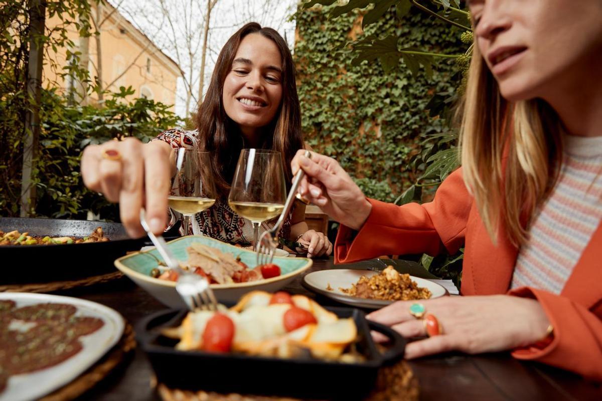 Dos jóvenes comiendo en un terraza de La Roca Village.