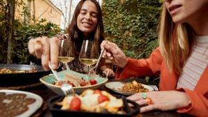 Dos jóvenes comiendo en un terraza de La Roca Village.