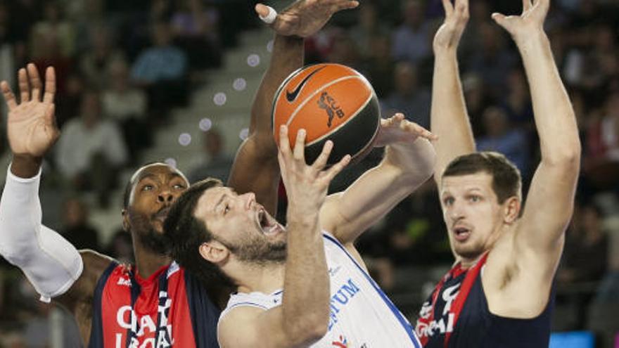 El pívot búlgaro del Lucentum Alicante Kaloyan Ivanov (i) lanza el balón ante el pívot bosnio del Caja Laboral Baskonia, Mirsa Teletovic (d) y el pívot estadounidense Joey Dorsey (d) durante el partido correspondiente a la séptima jornada de la liga ACB que disputan en el Iradier Arena.