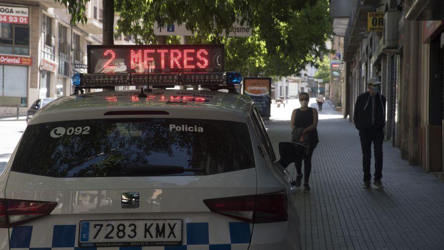 Un cotxe de la policia local de Manresa amb cartell lluminós amb advertència per als vianants durant l&#039;estat d&#039;alarma