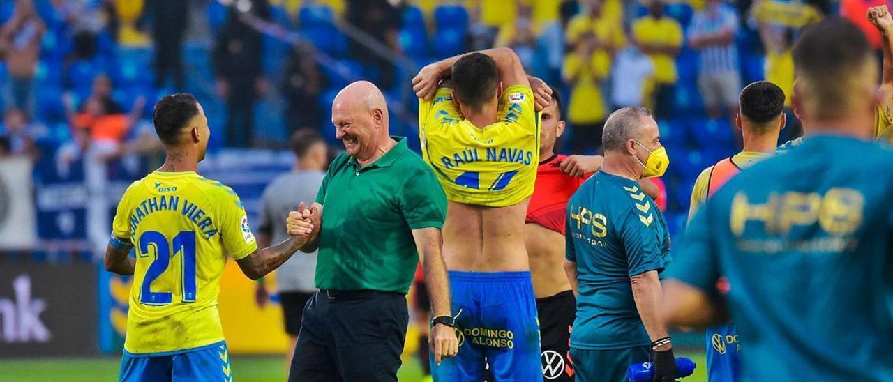 El técnico Pepe Mel y Jonathan Viera se saludan al final del derbi que la UD ganó al Tenerife mientras Raúl Navas se quita la camiseta, el sábado en el Gran Canaria. | | ANDRÉS CRUZ