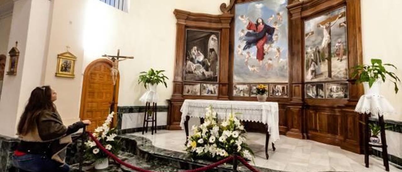 Una joven contempla el nuevo retablo de la parroquia de Guadalest.