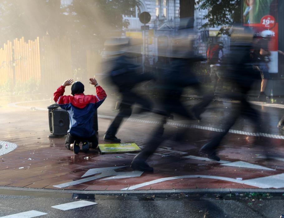 Un manifestante reacciona cuando la policía alemana pasa por delante de él durante una manifestación en la cumbre del G20 en Hamburgo, Alemania