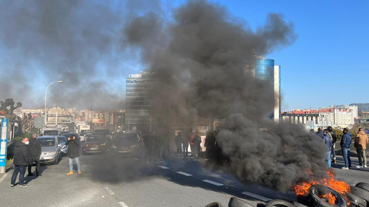 Acción de protesta de trabajadores de Alu Ibérica, con una barricada para cortar el tráfico en Alfonso Molina.