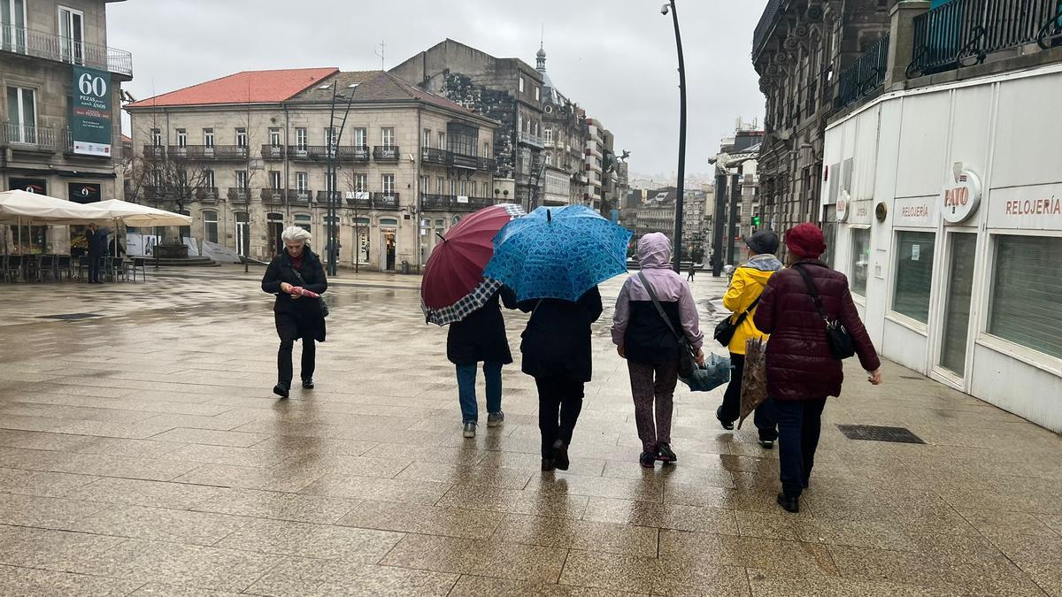 Grupo de mujeres con paraguas y chubasqueros en Porta do Sol, esta mañá.