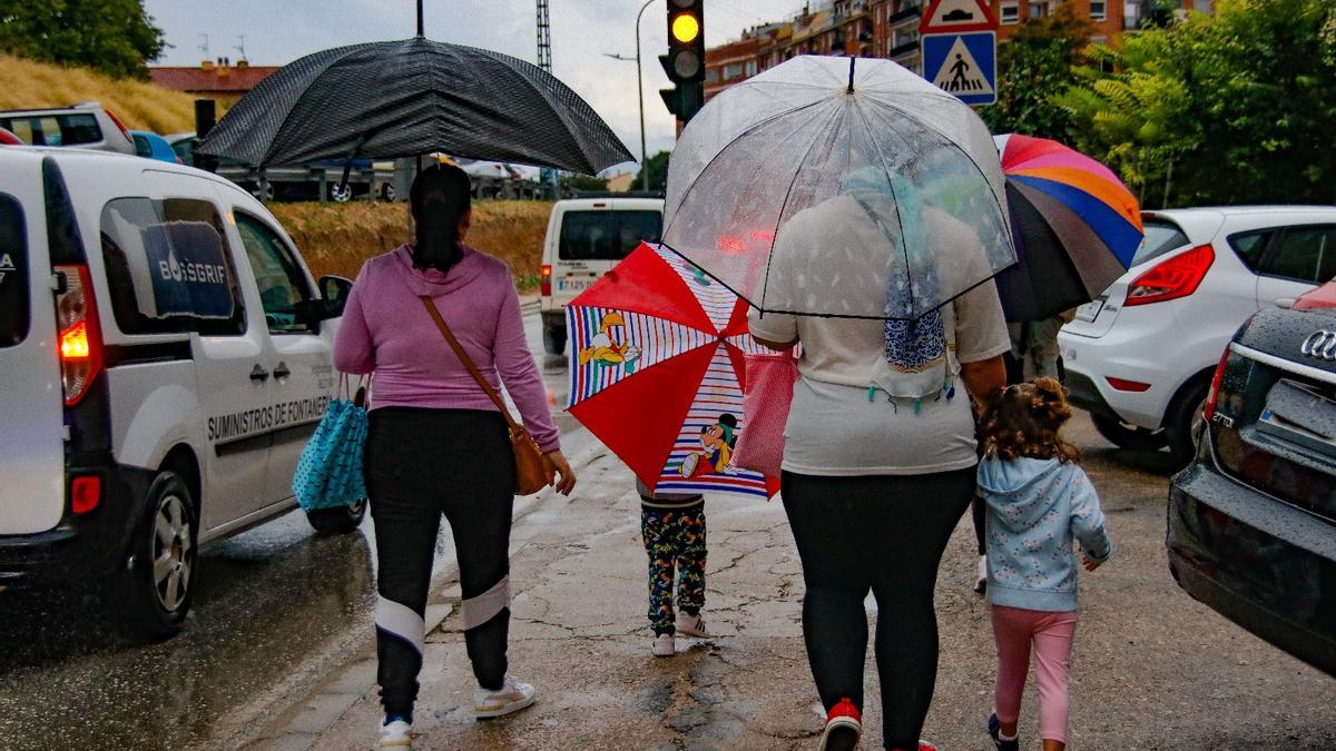 Varias personas pasean bajo la lluvia en Alcoy