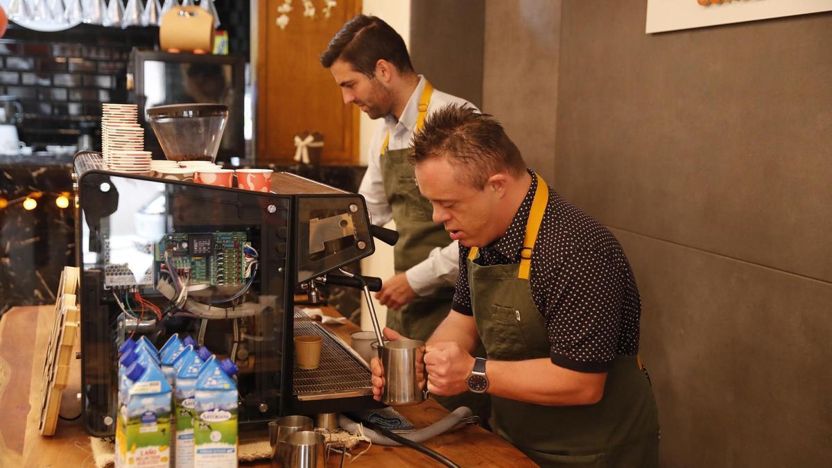 Dos baristas preparan cafés.