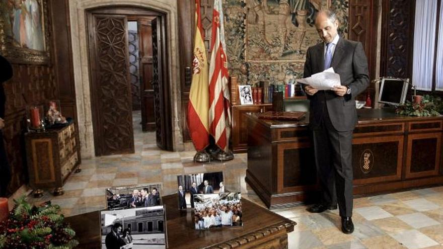 Camps elige fotos de Pla, Berlanga, Barberá y Rajoy en su despacho mientras prepara el discurso.