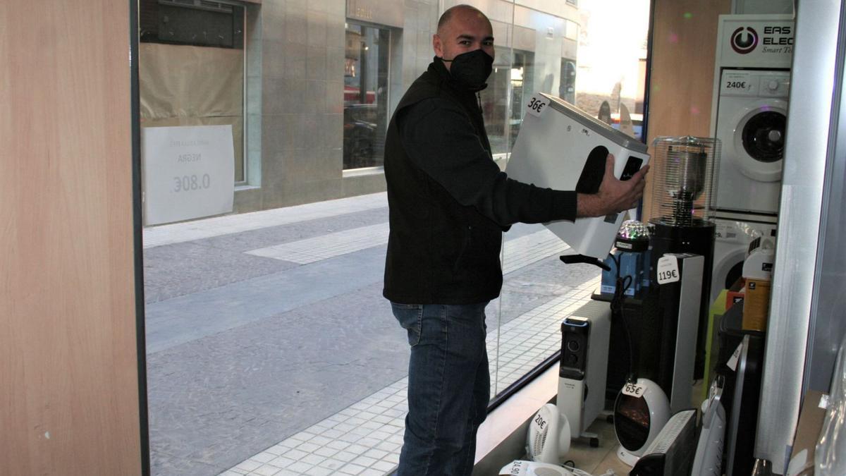 Mariano Mateo, con unade las estufas del escaparate de la tienda.