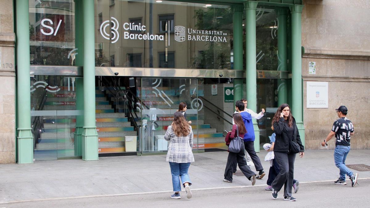 Diverses persones creuen el pas de vianants davant l'Hospital Clínic.