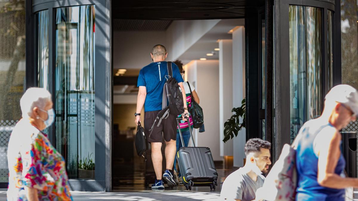 Un turista entra en uno de los escasos hoteles abiertos en Benidorm este invierno.