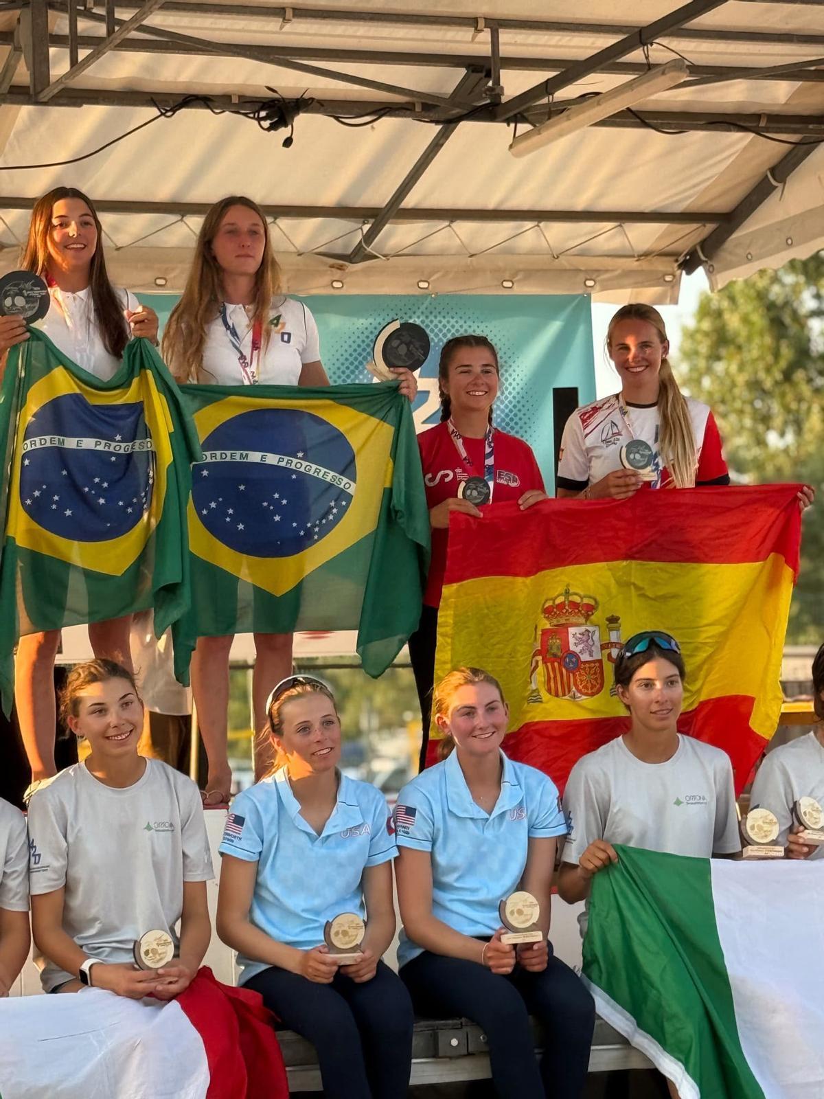 Las mallorquinas, con la bandera española, con su medalla, junto a la tripuación brasileña ganadora.