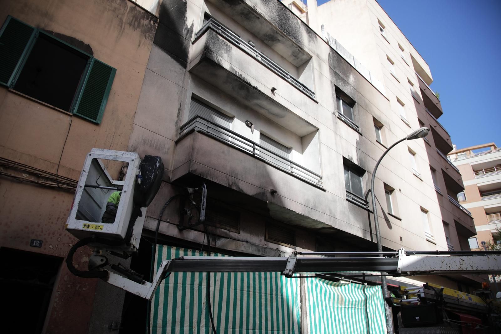 Un incendio destruye contenedores, coches y la fachada de una casa en Palma