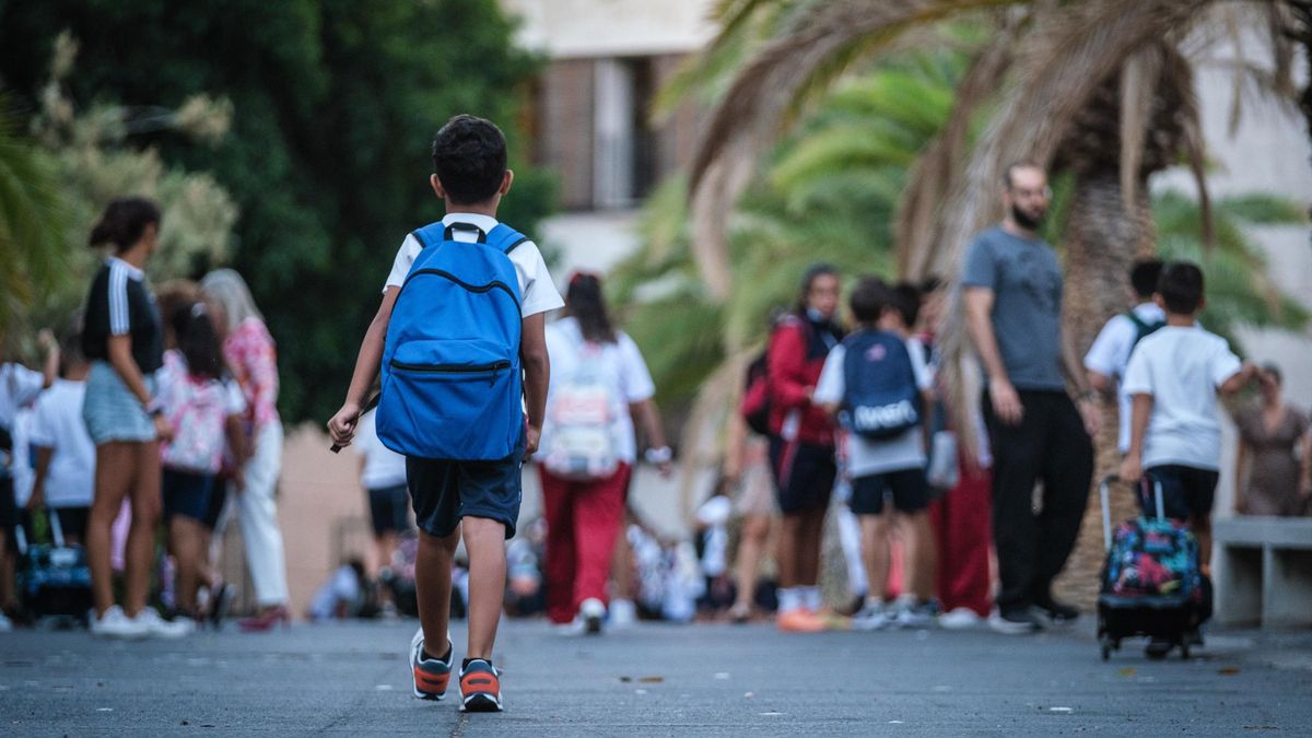 Un niño entra a su colegio el primer día de clase.