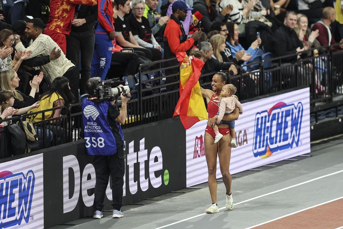 La atleta Ana Peleteiro celebra con su hija la medalla de bronce obtenida en el Mundial de pista cubierta de Glasgow.
