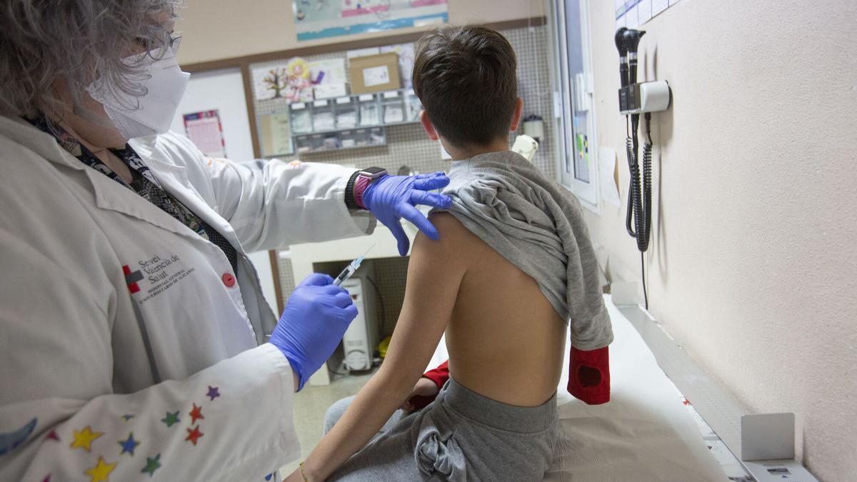 Una enfermera vacuna a un niño de la gripe.
