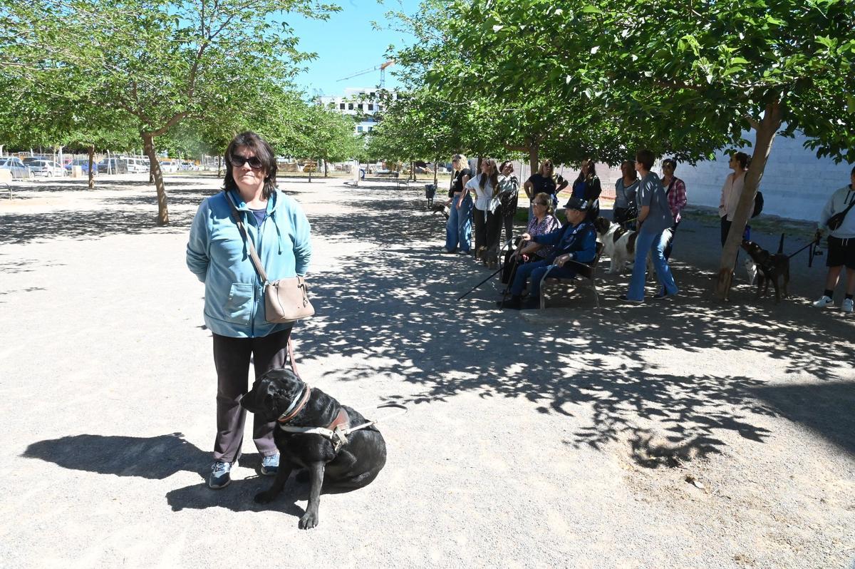 Carmen, junto a su perra guía en el pipicán.