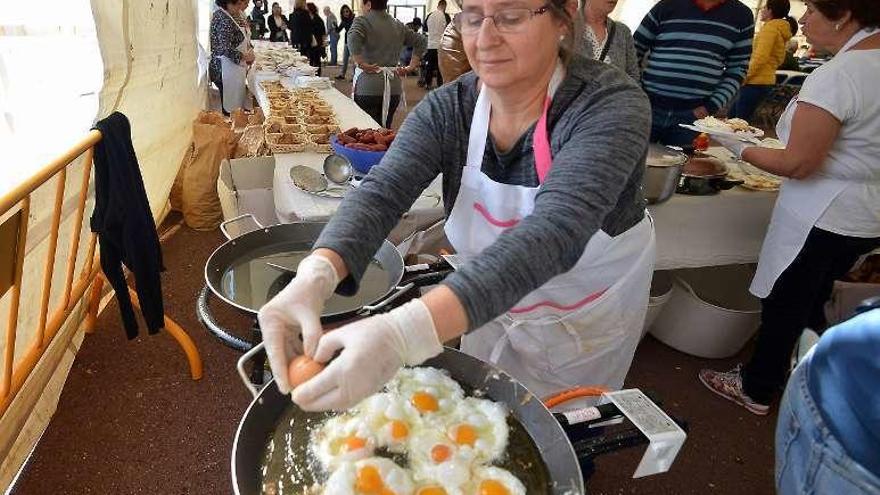 La cocinera fríe los huevos en la sartèn. // G.S,