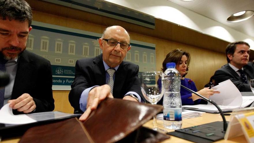 El ministro Cristóbal Montoro y la vicepresidenta, Soraya Sáenz de Santamaría, al comienzo de la reunión del Consejo de Política Fiscal y Financiera.