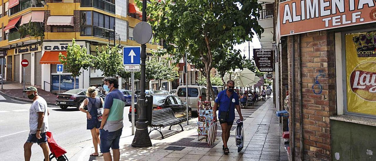 Vecinos de El Campello, con mascarilla, pasean por el municipio, ayer, en una mañana marcada por el intenso calor.